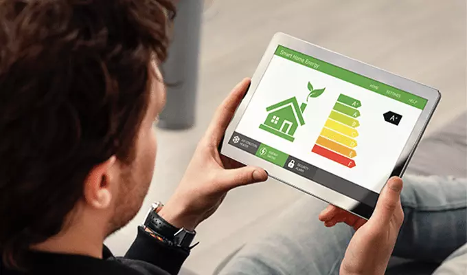 Mężczyzna patrzący w tablet na którym wyświetlają się klasy energetyczne