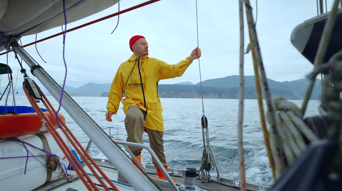 Mężczyzna na jachcie przegląda stronę internetową na komputerze