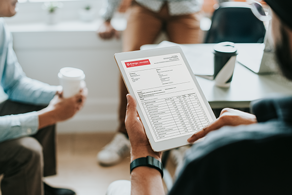 Właściciel firmy analizuje dane z erozliczenia na swoim tablecie