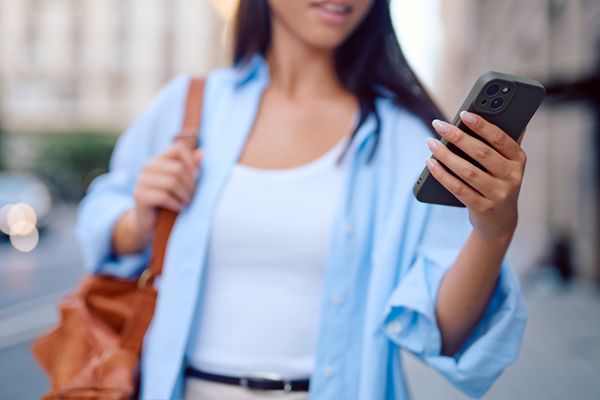 Właścicielka firmy idąc ulicą sprawdza powiadomienie o otryzmaniu eRozliczenia na telefonie