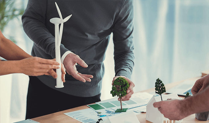 Biznesman trzymający model farmy wiatrowej