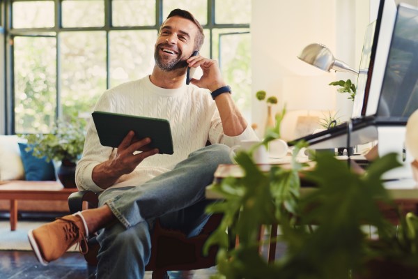soba korzystająca z tabletu i telefonu podczas przeglądania danych zużycia energii.