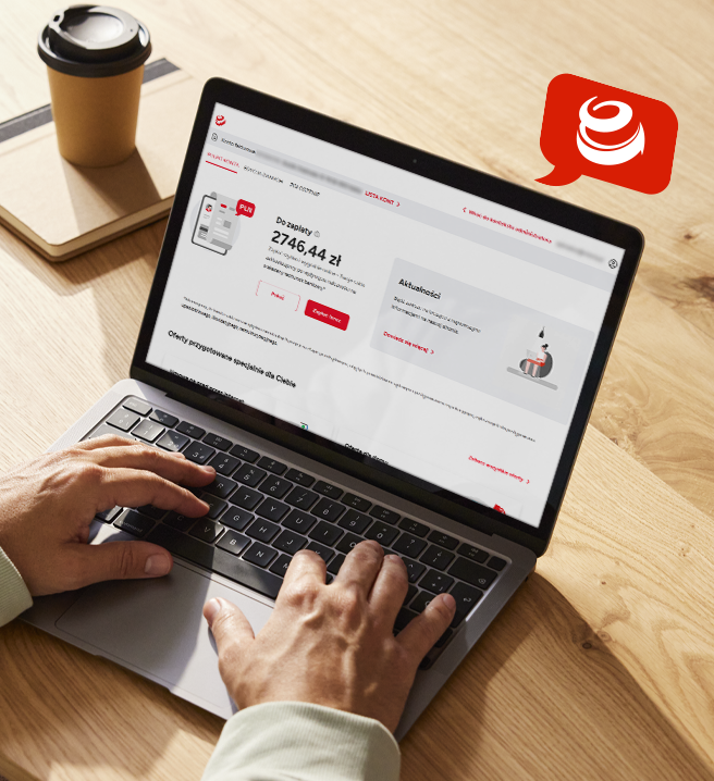 Mężczyzna piszący na laptopie, na którego ekranie widoczna jest strona ENERGA24. Obok laptopa na drewnianym stole stoi kawa i leży notatnik.