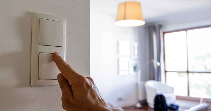 Ręka mężczyzny, który wyłącza światło w mieszkaniu