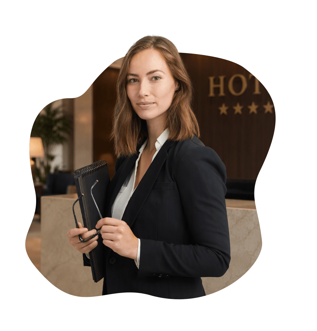 Pracownik branży hotelarskiej w stroju biznesowym z notesem w dłoni.